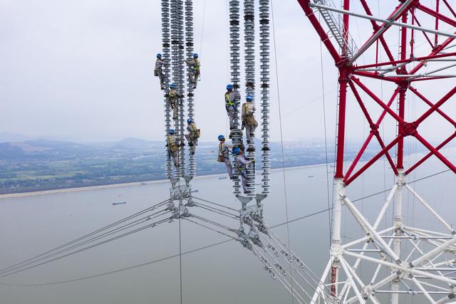 西电东送工程的战略大动脉,施工人员在300多米高空进行特高压跨江作业